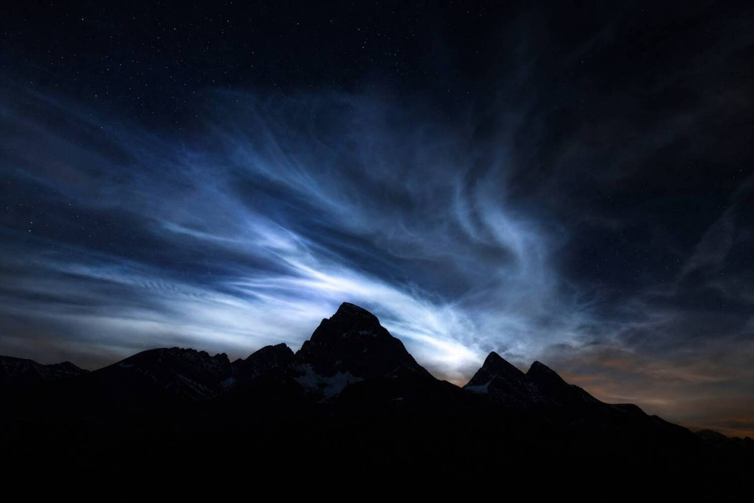 Atmospheric lights in nighttime mountain sky